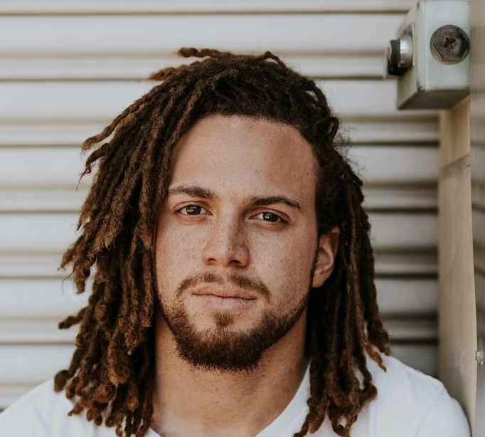 man with dreadlocks in a white t-shirt